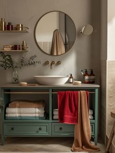 a bathroom with a sink, mirror and towels on the shelf in front of it