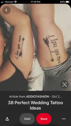 two people with tattoos on their arms laying next to each other and one has an arrow