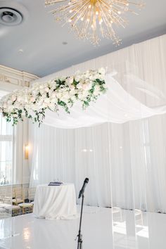 a wedding setup with white flowers and chandelier