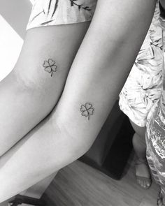 two women with tattoos on their legs and one has four leaf clovers tattooed on her leg