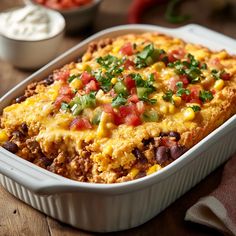 a casserole dish with corn, black beans and salsa in it on a wooden table