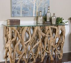 a table made out of driftwood with books on top and vases sitting next to it