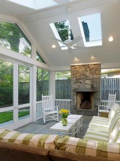 a living room filled with furniture and a fire place in the middle of a patio