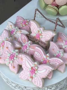 decorated cookies are sitting on a plate next to some buns and other pastries