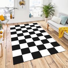 a black and white checkered area rug in a living room with couches, coffee table and potted plants