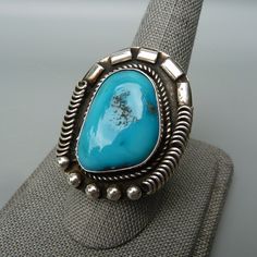 Vintage Native American Turquoise Ring, Southwest Turquoise Ring, Sleeping Beauty Turquoise Ring, Vintage Navajo Turquoise Ring, Gift For Her This listing is for a gorgeous vintage Native American sterling silver ring with a large turquoise gemstone, size 9. This ring is probably a Navajo design and it has a large bezel set sky blue turquoise gemstone which I believe is from the Sleeping Beauty mine in northern Arizona. The band is a split style with a rope design. The setting has a rope, coil a Western Style Turquoise Ring Collectible, Western Style Turquoise Gemstone Rings, Southwestern Style Turquoise Ring With Large Stone, Southwestern Style Large Stone Turquoise Ring, Bohemian Blue Collectible Ring, Southwestern Turquoise Ring With Large Stone, Southwestern Chrysocolla Turquoise Ring, Vintage Blue Cabochon Turquoise Ring, Native American Turquoise Ring