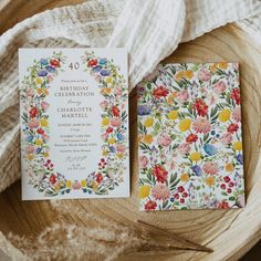 the wedding stationery is laid out on top of a wooden bowl with white linen