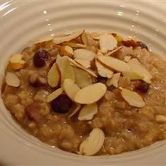 oatmeal with almonds and cranberries in a white bowl on a table