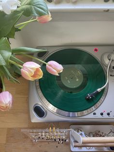 an old record player with flowers in front of it