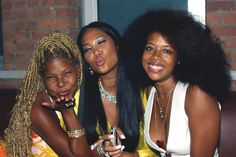 three women sitting next to each other posing for the camera with their fingers on their lips