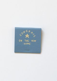 a blue square magnet with the words congrats on the new home written in gold