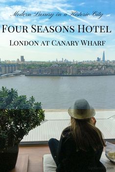 a woman sitting at a table looking out over the water with text that reads four seasons hotel london at canary wharf