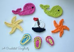 crocheted sea animals and seashells are arranged on a white surface