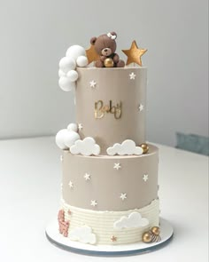 a three tiered cake decorated with teddy bears on top and stars in the sky