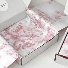 two open boxes with pink and white designs on them