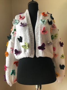 a white sweater with multicolored butterflies on it