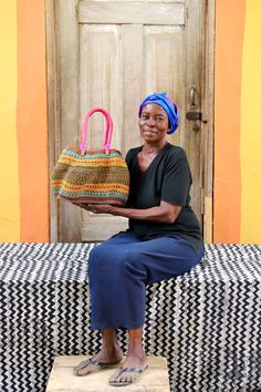 a woman sitting on a bench holding a basket