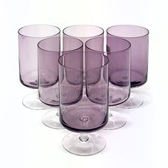 six purple glasses are lined up in a row