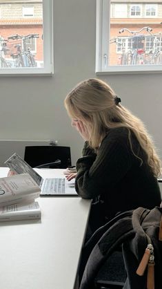 a woman sitting at a table using a laptop computer