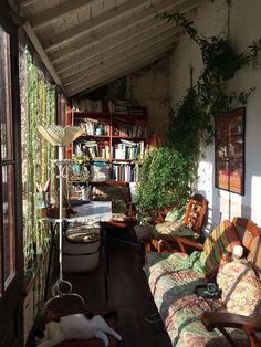 the sun shines through an open room with bookshelves and couches in it