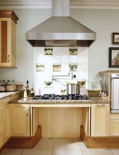 a stove top oven sitting inside of a kitchen next to wooden cabinets and counter tops