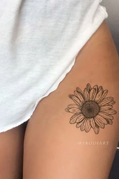 a woman's thigh with a sunflower tattoo on it