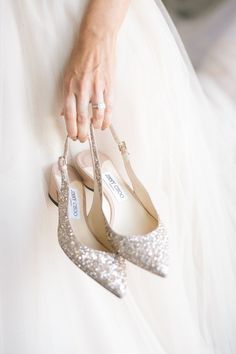 the bride's shoes are being held up by her mother, who is wearing a white dress