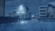 a snowy street at night with snow on the ground and buildings in the background,