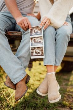 a man and woman sitting on a bench with their feet up in the air holding photos