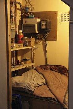 a small room with a bed, microwave and other items