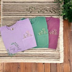 These embroidered floral pocket tees make the perfect Spring/Summer shirts! Check out our page for these shirts in more colors! if you don't see a color you want please message and we can discuss other options.  **shirt colors may vary slightly from shirt to shirt depending on dye. please use the color chart in the last picture for a truer color** ORDERING & SHIPPING *Your item will be shipped within 5-7 business days. *Please allow 2-5 business days to receive your item, more time may be necess Flower Girl Shirts, Pocket Tees, Pocket Tee Shirts, Spring Clothing, Comfort Colors Tshirt, Botanical Shirt, Floral Pocket, Embroidered Crewneck, Flower Shirt