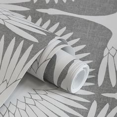 a grey and white wallpaper with an abstract design on it's side, next to a roll of tape