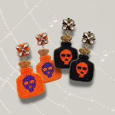 three pairs of beaded earrings with skulls on the front and one has an orange bottle