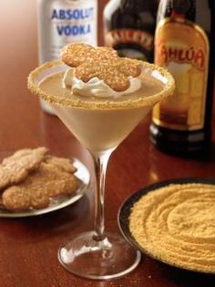 a drink and some cookies on a table next to bottles of booze, beer and crackers