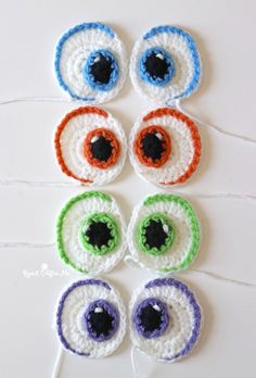 crocheted eyeballs are arranged on a white surface