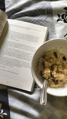 a bowl of oatmeal next to an open book