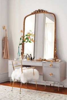 a vanity with a chair and mirror in a room