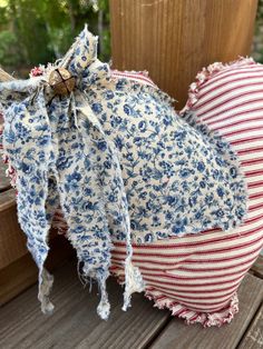 a red, white and blue flowered pillow sitting on top of a wooden bench