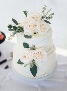 a wedding cake with white flowers and greenery