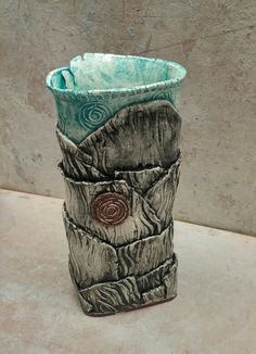 there is a vase that has been made out of tree stumps and other things