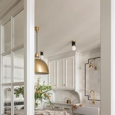 a kitchen with white cabinets and gold accents