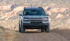 a grey truck driving down a dirt road