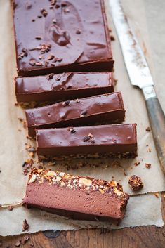 pieces of chocolate cake sitting next to a knife