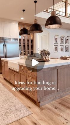 a large kitchen with an island in the middle and two pendant lights hanging from the ceiling