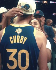 a man wearing a jersey that says curry in front of him and people behind him