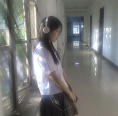 a woman with headphones standing in a hallway