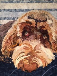 a close up of a dog's face on a piece of fabric with stripes in the background