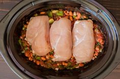 two raw fish fillets in a crock pot with beans and broccoli