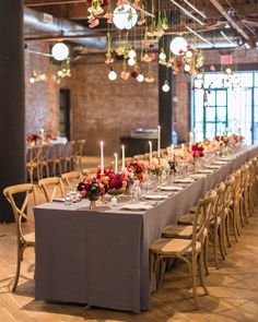 a long table is set up with candles and flower centerpieces for an event