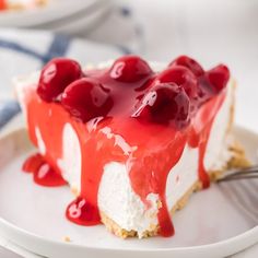 a piece of cheesecake with cherries on top is sitting on a white plate